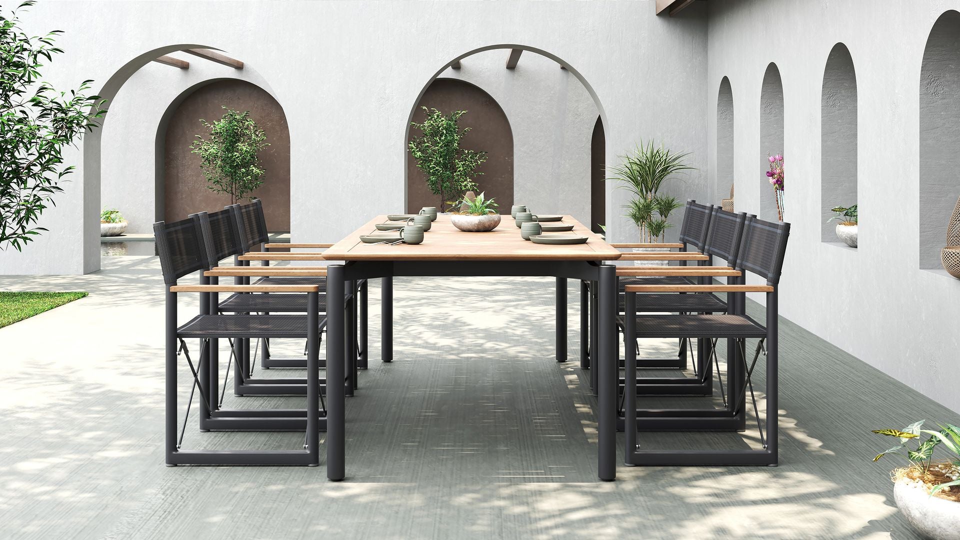A full outdoor dining set with a teak table and eight black Aleta director chairs by Be A Little.