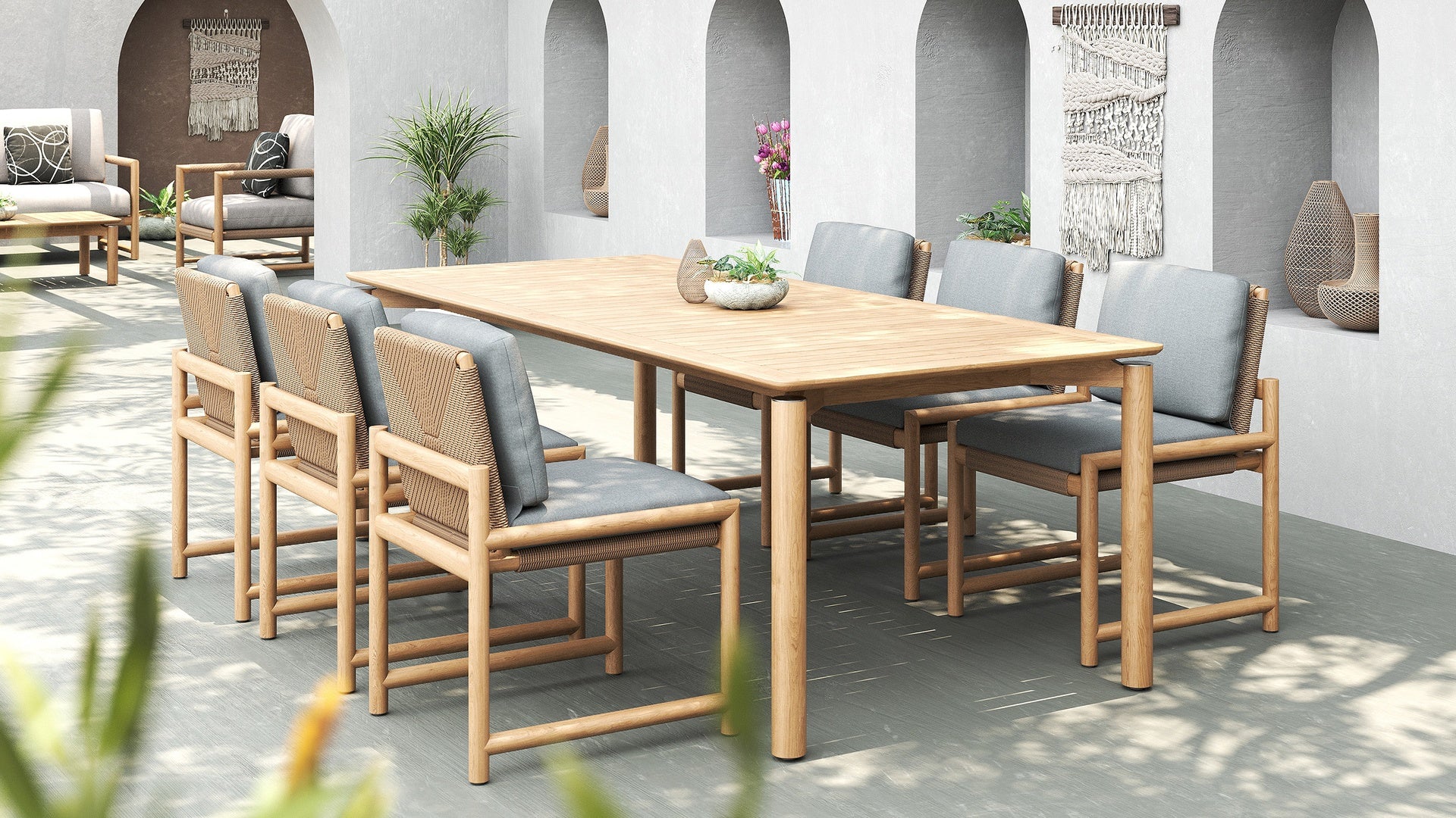 Outdoor dining set with a large wooden table and eight chairs with woven backs and grey cushions.