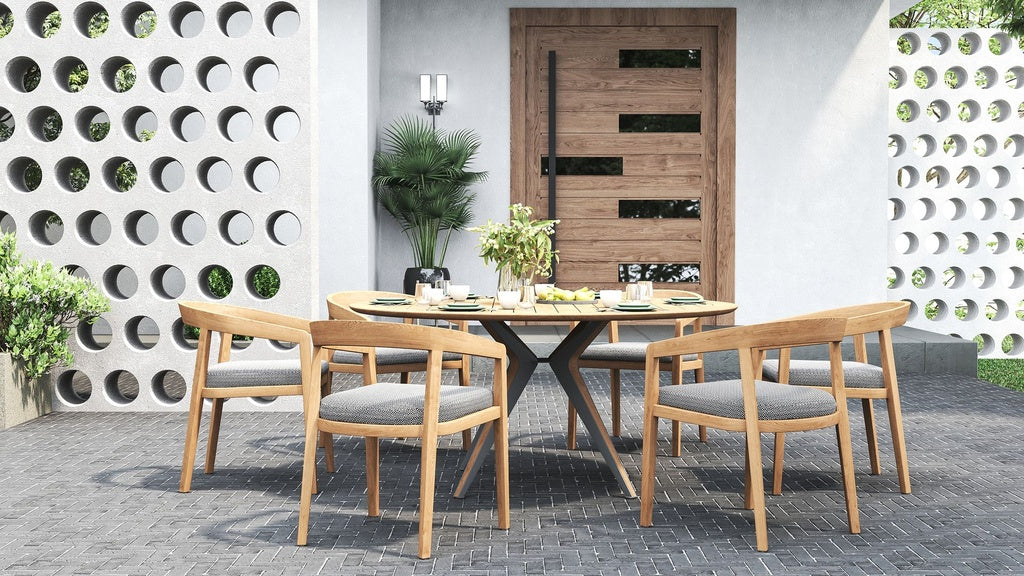 Outdoor dining set with a round table and 4 outdoor dining chairs on a patio with a perforated wall.