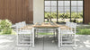 Full outdoor dining set with a premium teak table and six Aleta director chairs with white frames.