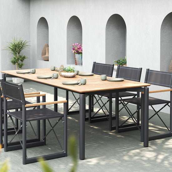 Large outdoor dining set with a teak table and six black Aleta director chairs from Be A Little.