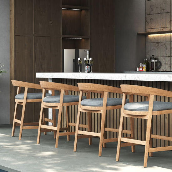 Modern wooden counter stools with grey cushions arranged with an outdoor marble-top bar by the pool.