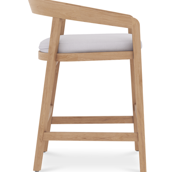 Side profile view of Vento counter stool featuring a teak wood frame and padded white fabric seat.
