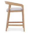 Side profile view of Vento counter stool featuring a teak wood frame and padded white fabric seat.