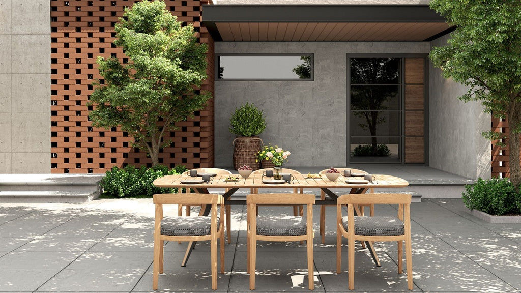 Outdoor dining set with a rectangular table & six Vento dining chairs with gray cushions on a patio.