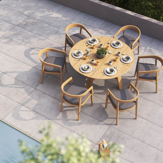 Overhead view of a round outdoor set with 6 dining chairs, & a small serving trolley nearby a pool.