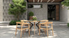Outdoor dining set on a tiled patio, with a round wooden table & 4 dining chairs with gray cushions.