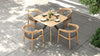 Overhead view of a square outdoor dining table with four dining chairs and gray cushions on a patio.