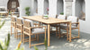 Outdoor dining setup with Timo dining armchairs and a wooden teak table in a modern patio setting.