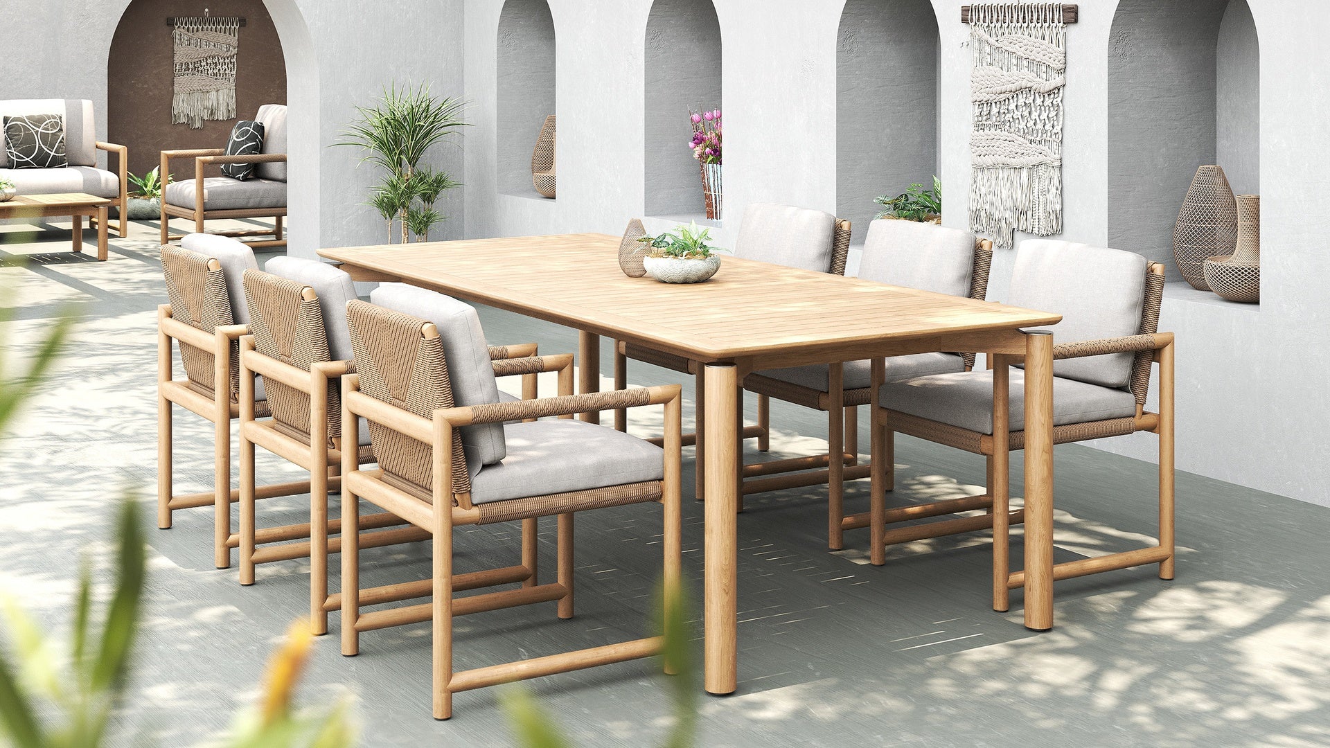 Outdoor dining setup with Timo dining armchairs and a wooden teak table in a modern patio setting.